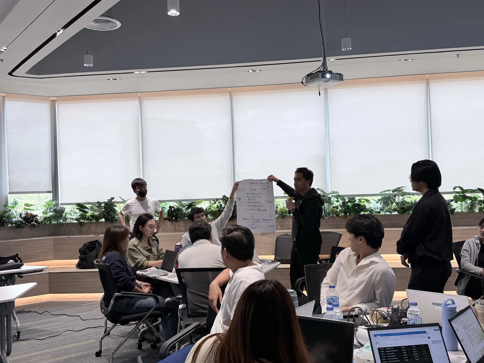 A participant presenting a handwritten worksheet to colleagues during a workshop.